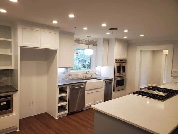 Modern kitchen with white cabinets, stainless steel appliances, and a large island.