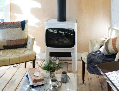 Cozy living area with a wood stove and comfortable chairs.