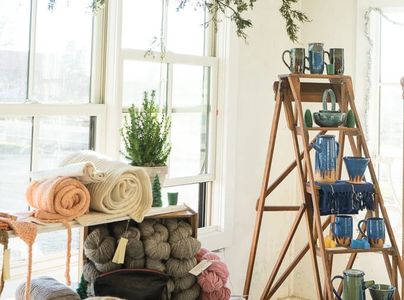 Cozy yarns, towels, and ceramics displayed near windows.