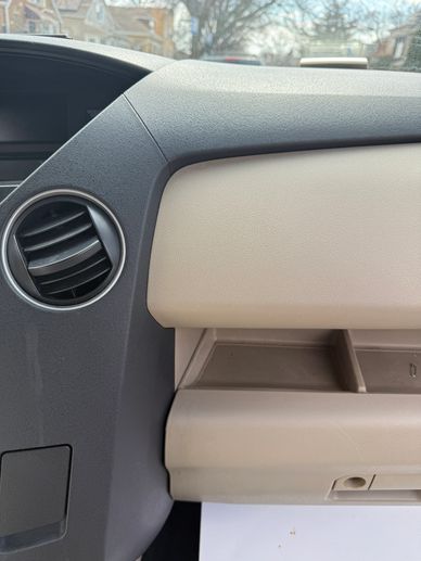 Close-up of a car dashboard showing air vent and glove compartment.