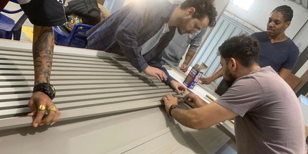 A group of men assembling a large object indoors.