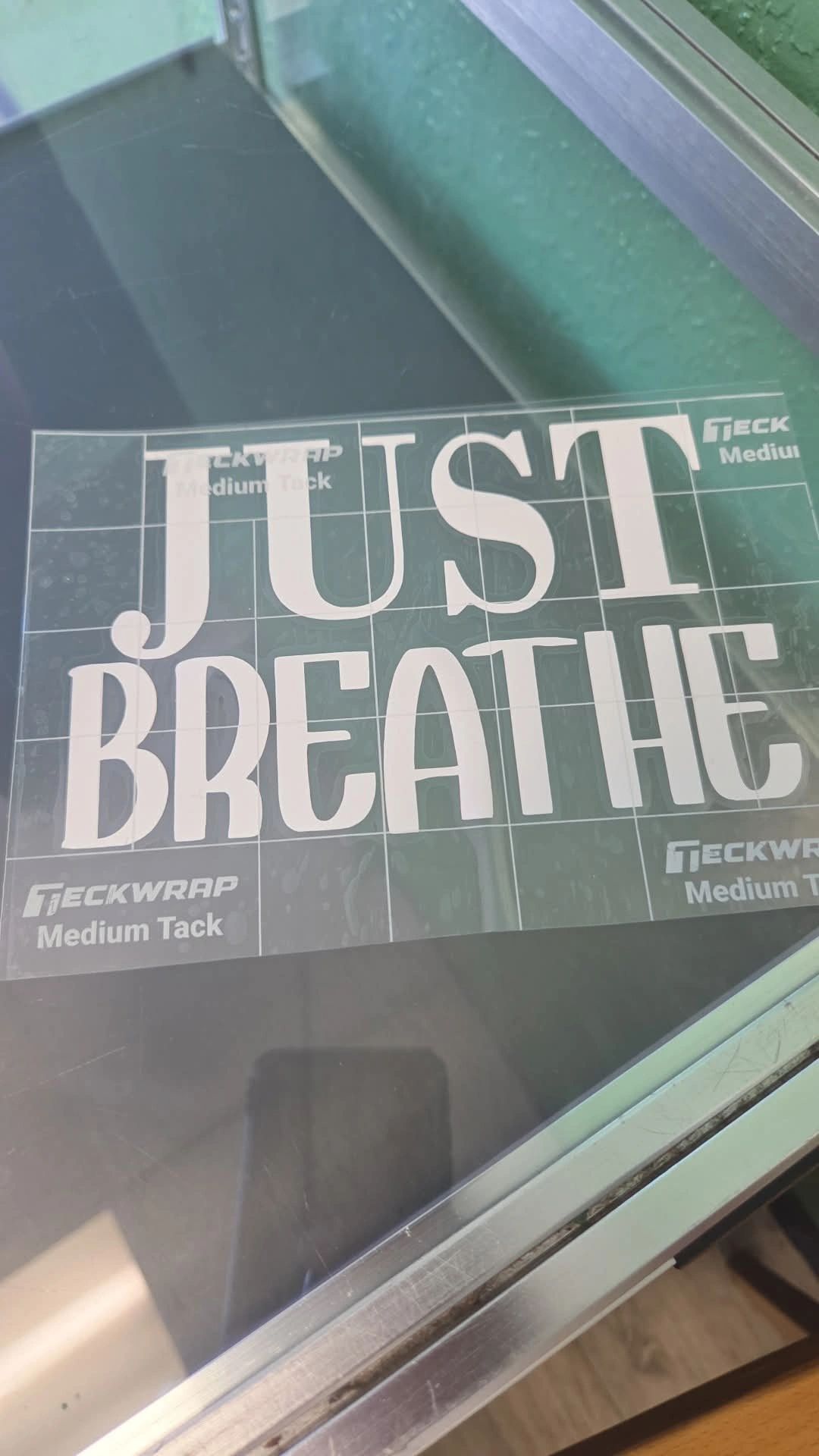 Sticker sheet with the phrase 'JUST BREATHE' on a glass surface.