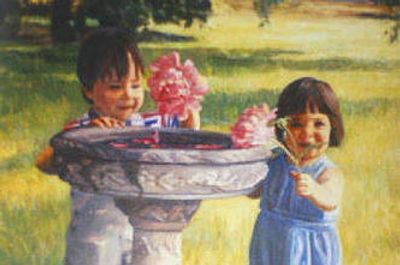 Two children playing with flowers beside a birdbath on a sunny day.