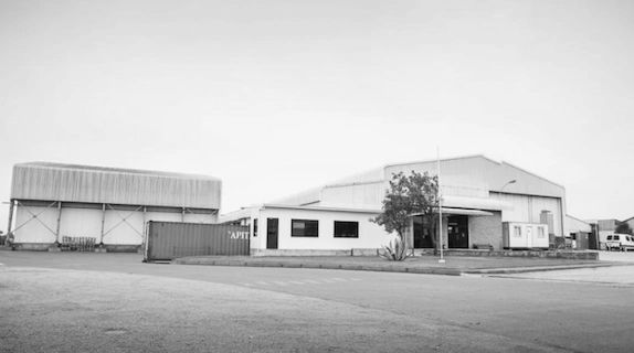 Edificio industrial con un contenedor rojo en blanco y negro.