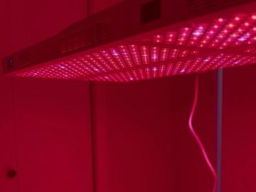 A red LED grow light panel illuminating a room in red.