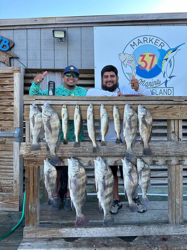 Two men proudly display their large catch of fish at Marker 37 Marina.