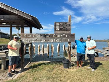 Three men posing with their catch at San Patricio County Navigation District.