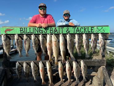 Two men proudly display their catch at Billings Bait &amp; Tackle.