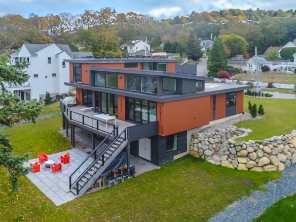 Modern multi-level house with outdoor seating and stone landscaping.