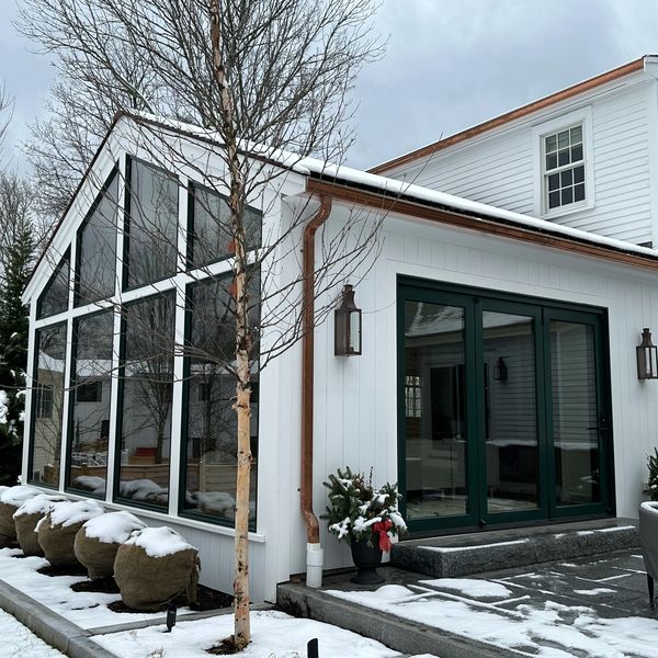Modern house extension with snow and large windows.