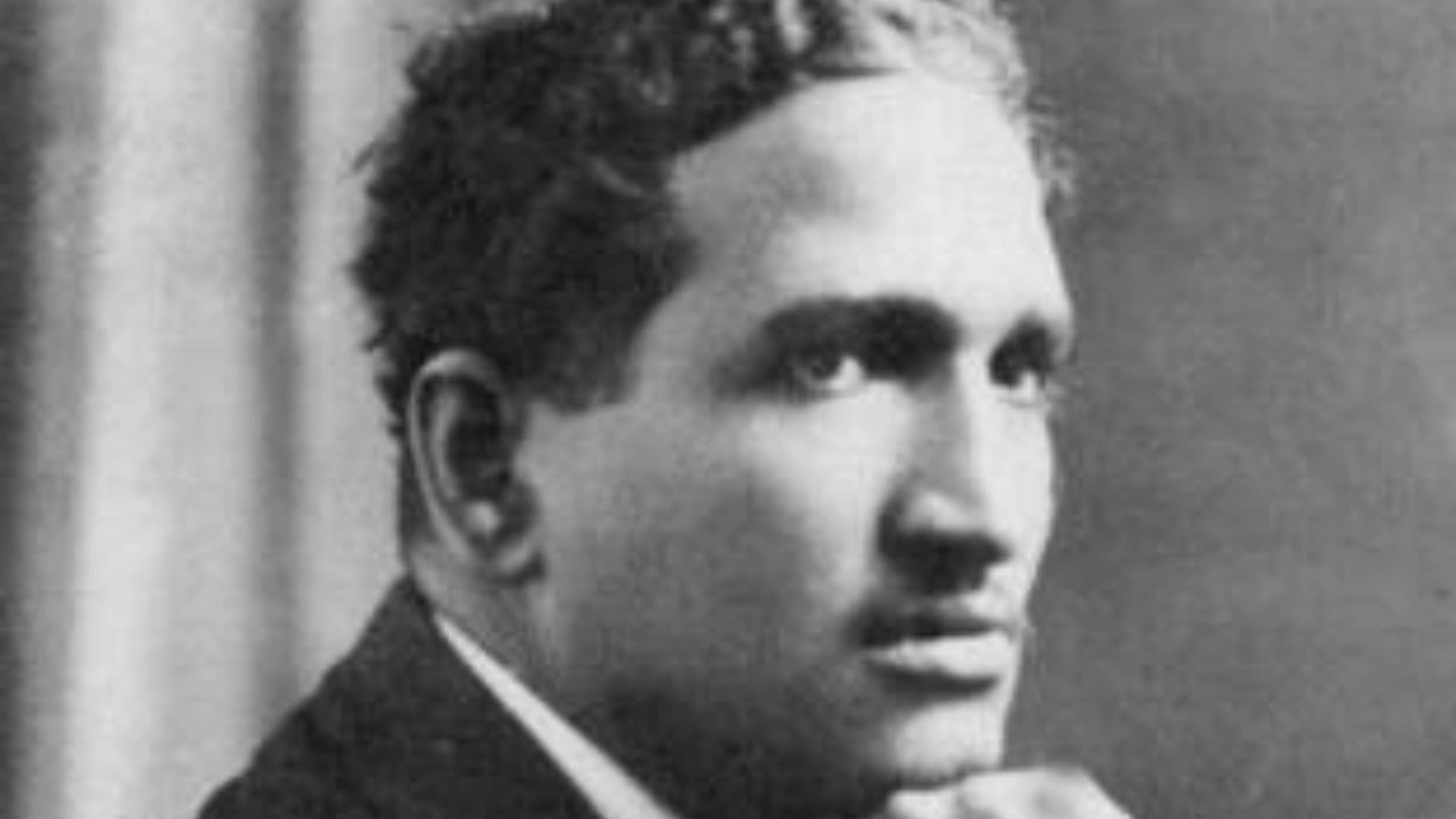 Black and white portrait of a thoughtful man in a suit.