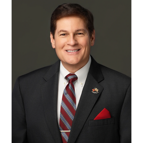 Professional man in a dark suit with a red-striped tie and a red pocket square.
