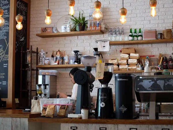 Cozy coffee shop interior with vintage espresso machines and warm lighting.