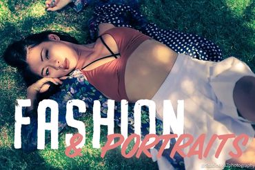 Woman in blue button up and terra cotta bikini top and white skirt lies in dappled light in the gras