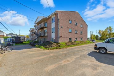 A multi-story brick apartment building under a clear blue sky.