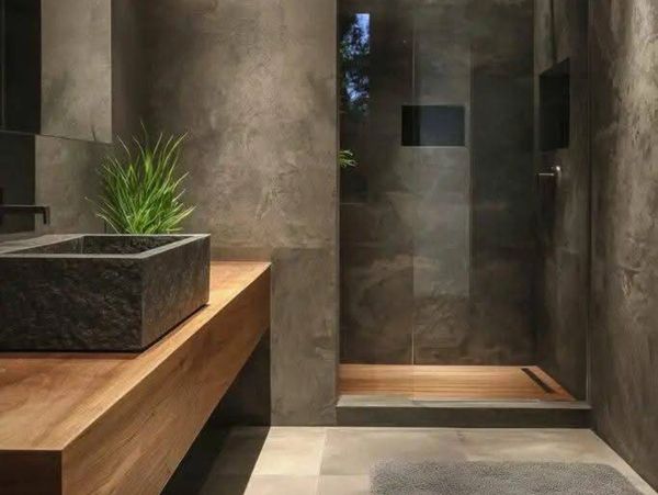 Modern bathroom with concrete walls, wooden countertop, and glass shower enclosure.