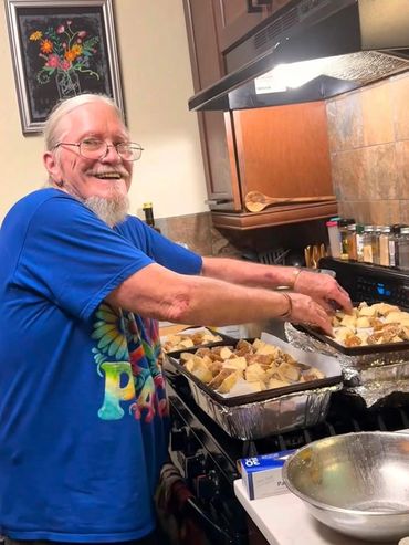 Elderly man preparing food in kitchen.