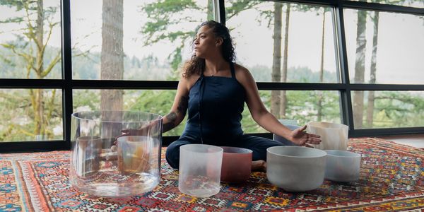 a woman, sound healer with her instruments, alchemy singing bowls
