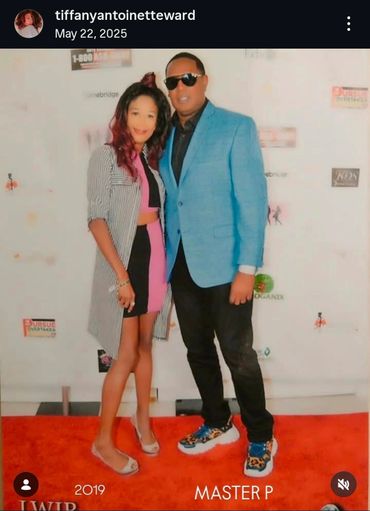 A man and woman posing on a red carpet event together.
