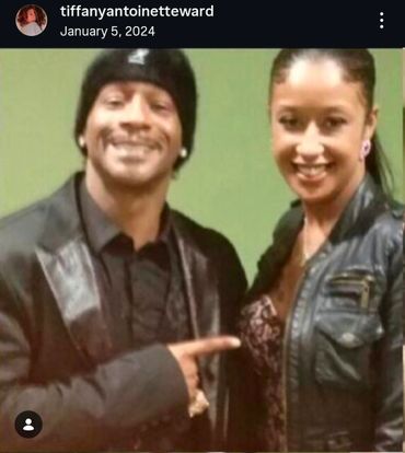 Two people smiling and posing for a photo indoors.