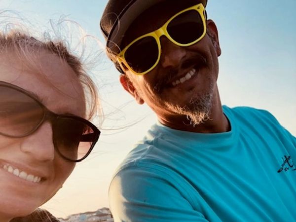 Two people smiling wearing sunglasses.