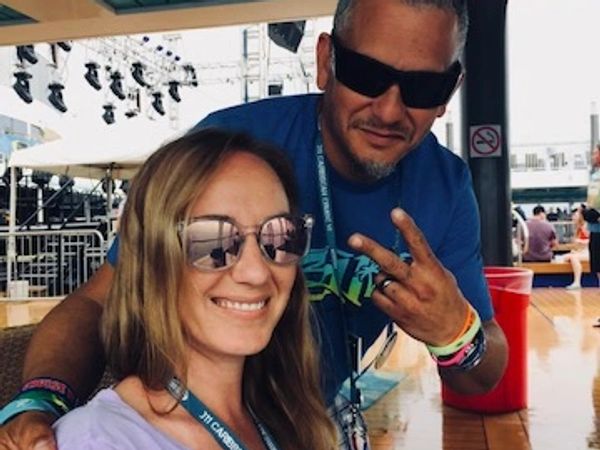 Smiling couple wearing sunglasses at an outdoor event.