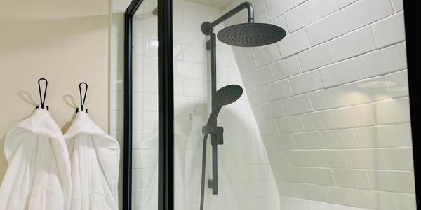 subway tile and shower with black accents, spa robes in dome