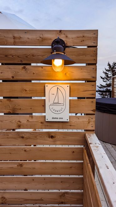 nova scotia glamping dome entry with sign, lamp on private deck