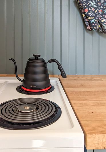 nova scotia glamping dome with full range and cooktop with kettle and beadboard backsplash