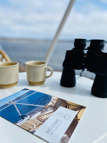 nova scotia dome coffee table with rental welcome brochure, binoculars, coffee mugs and ocean view