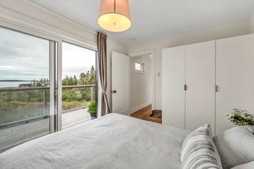 nova scotia cottage principal bedroom with wardrobe and patio doors.