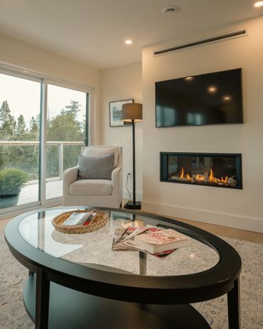 nova scotia cottage living room with propane fire place, coffee table, tv and chair.