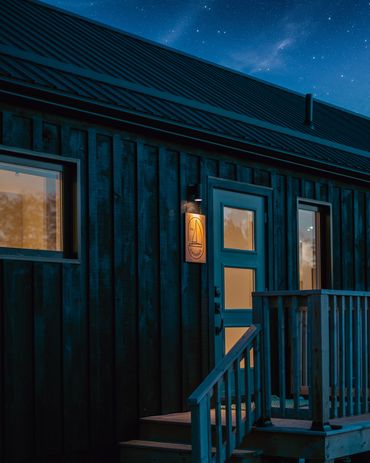 nova scotia cottage at night with soft glow of lights and deck