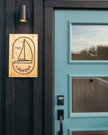 nova scotia cottage entry with The Lookout sign and blue painted door.