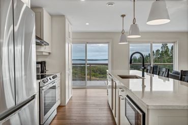 nova scotia cottage kitchen with fridge, range, hood, microwave, dishwasher. view of the ocean.