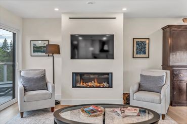 nova scotia cottage living room with fireplace, coffee table, tv, art and chairs