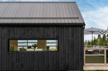 nova scotia cottage exterior showing expansive window and deck.