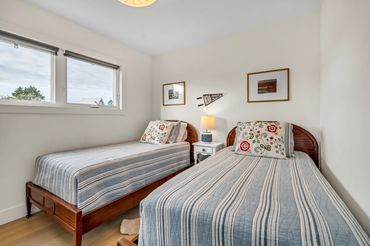 nova scotia cottage twin bedroom with antique beds, quilt bedding and art.