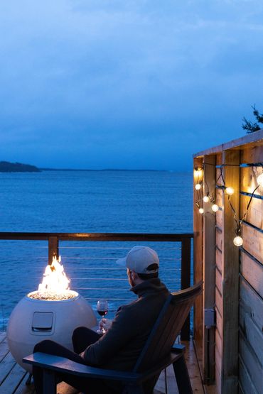 Nova scotia glamping dome with man overlooking ocean and fire pit