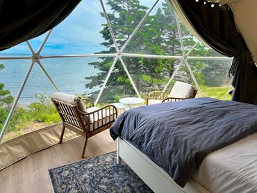 NS Dome bedroom and sitting area with ocean view and tree lined coast