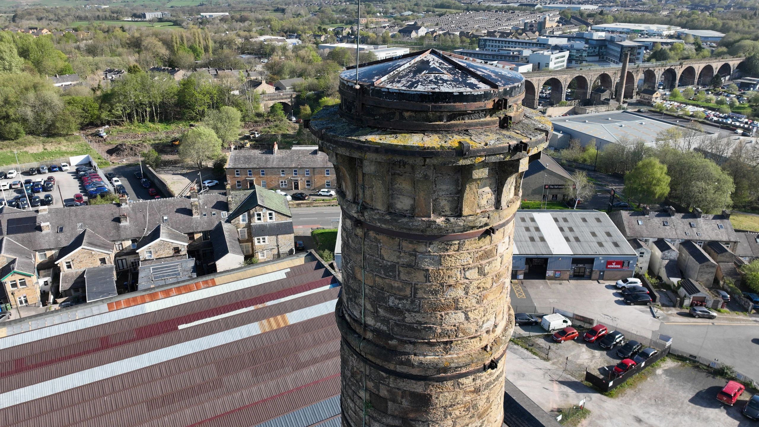 View from the top of a tall stone chimney overlooking town and a viaduct.