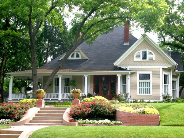 A house with a tree and decorative flowers in the front