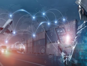 Worker managing logistics with digital interface and cargo containers.