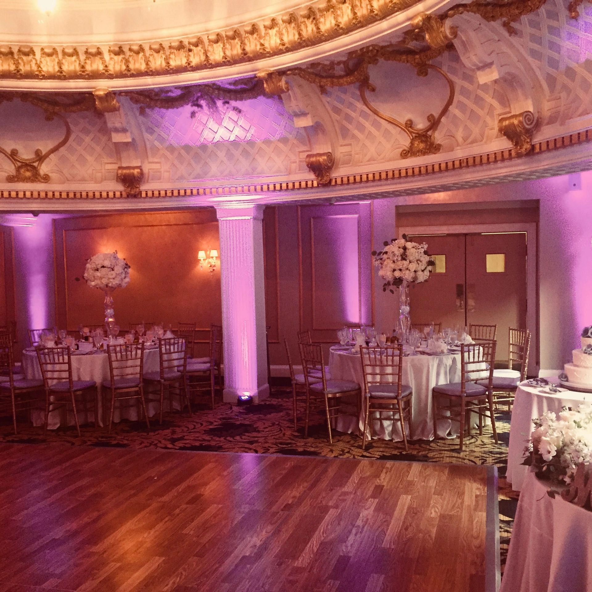 Elegant wedding reception setup with floral decorations and warm lighting.