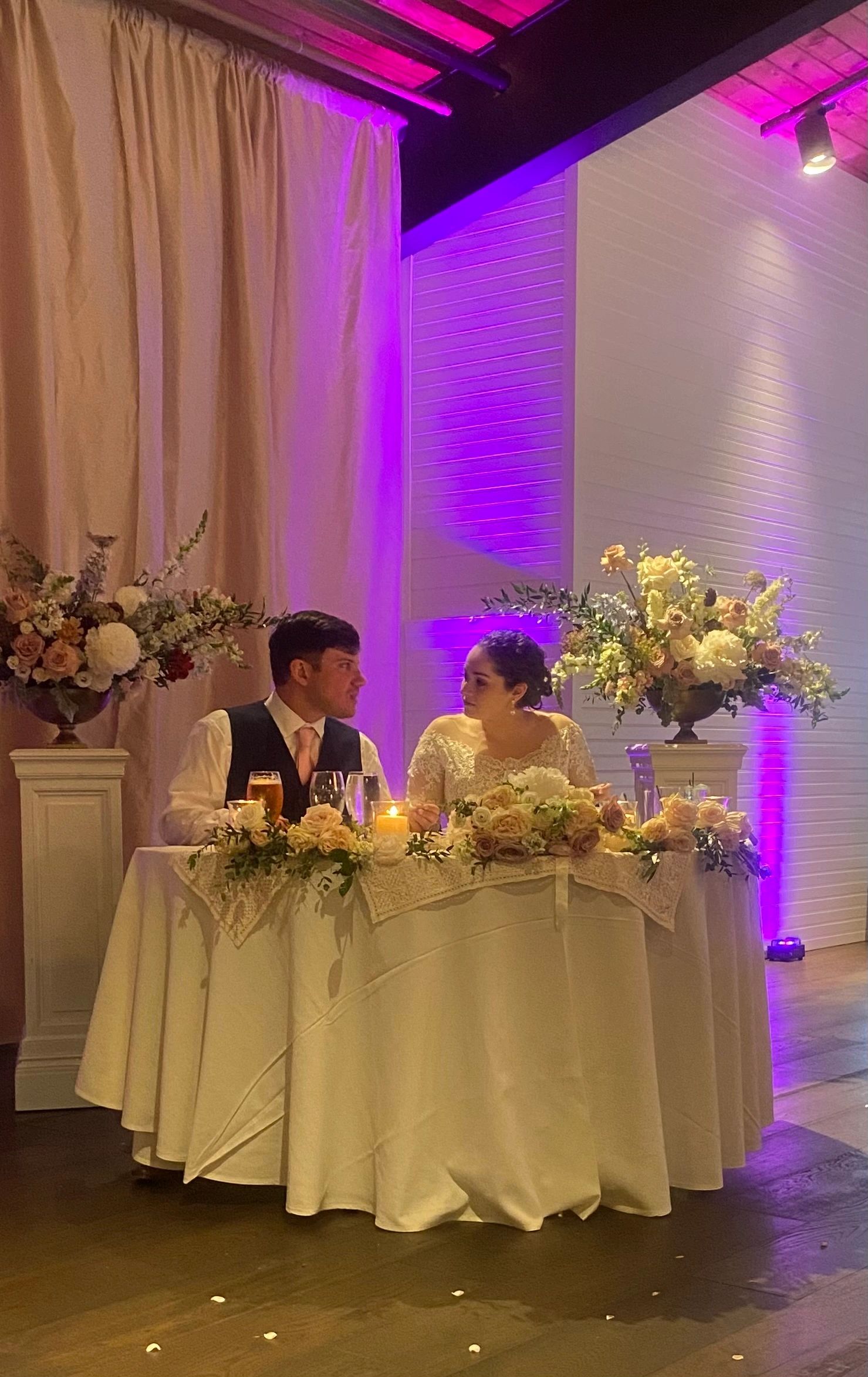 Bride and groom at a decorated wedding table.