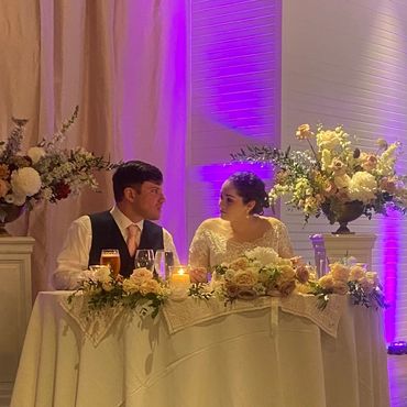 Bride and groom at a decorated wedding table.