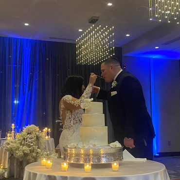 Bride and groom feeding each other cake at wedding.