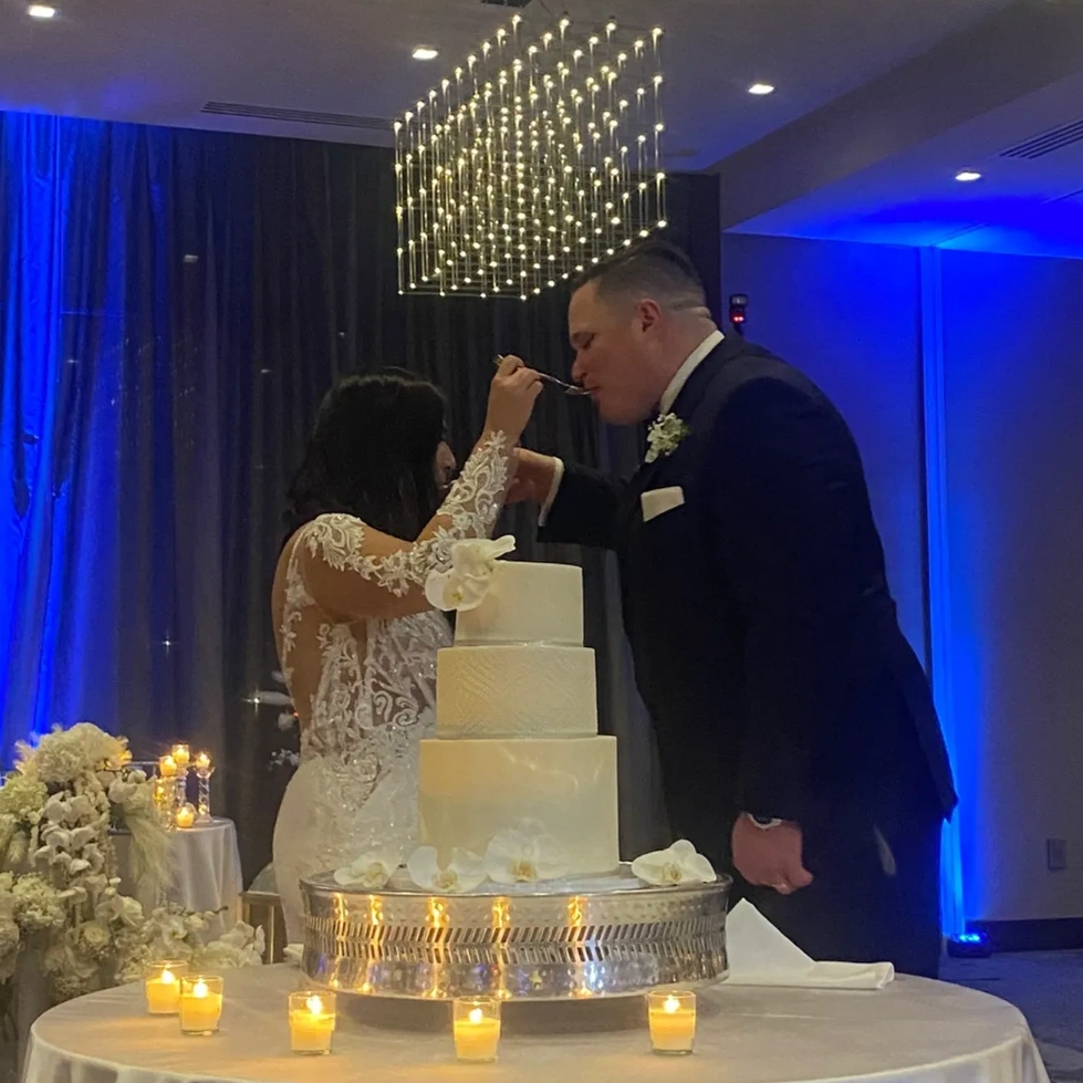 Bride and groom feeding each other cake at wedding.