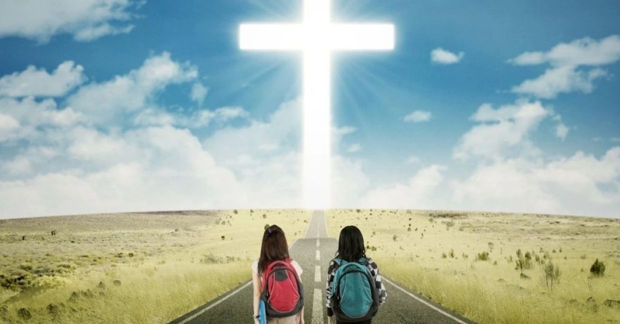 two kids walking on a path with a cross ahead 