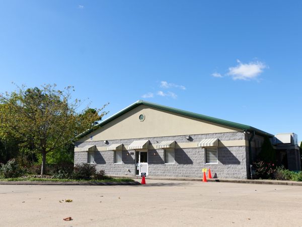 A small commercial building with awnings under a blue sky.
